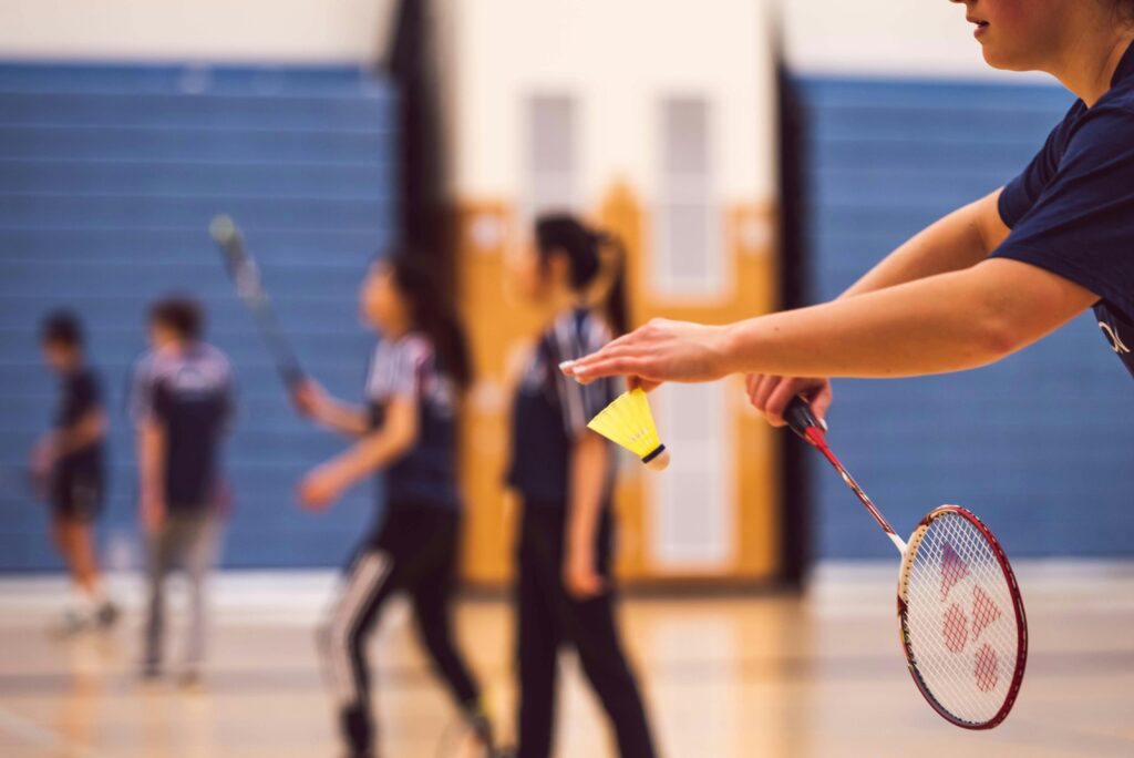pexels-photo-2202685-2202685 A group of young people enjoying a fun game of badminton indoors.